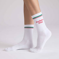 White socks with colorful stripes and 'La Dolce Vita' text on a light gray background